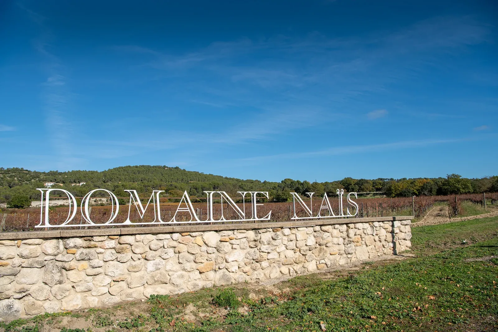 Enseigne du Domaine Naïs devant les vignes à Rognes en Provence