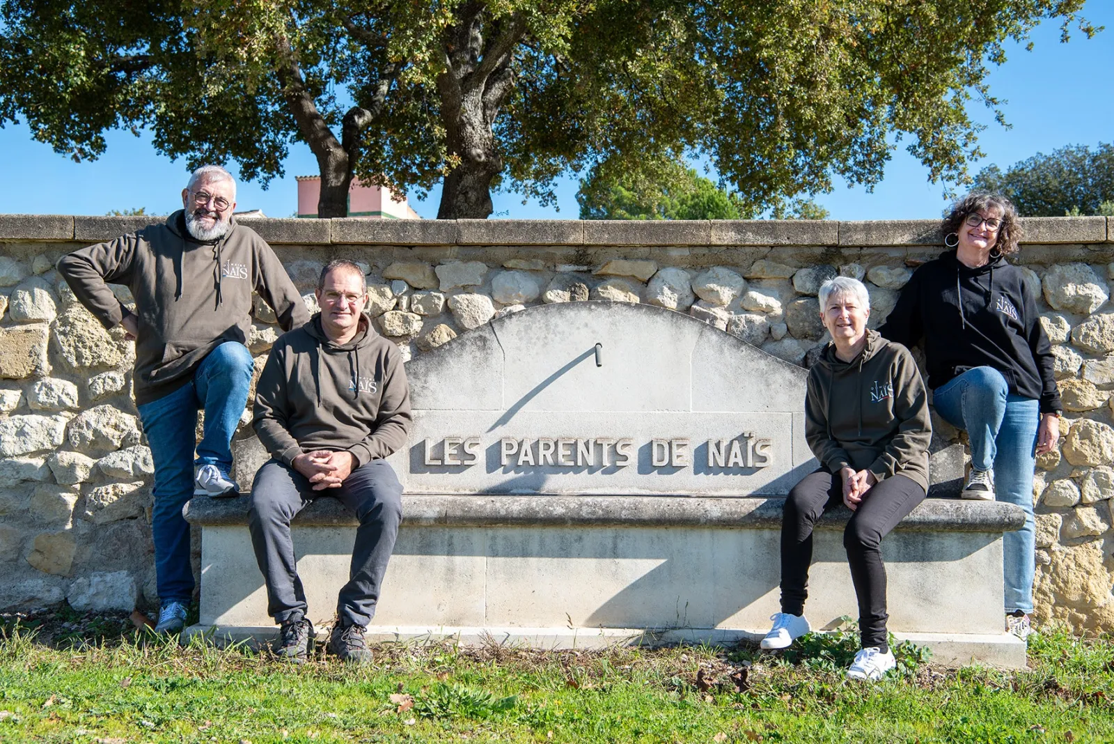 Les fondateurs du Domaine Naïs assis devant la fontaine Les Parents de Naïs